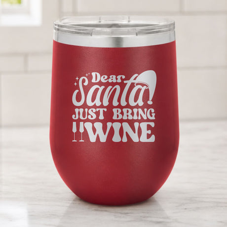 Maroon 12 oz stemless wine tumbler laser engraved with "Dear Santa, Just Bring Wine", on a kitchen counter