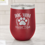 Maroon 12 oz stemless wine tumbler laser engraved with the Social Club "Dog Mom" design, on a kitchen counter