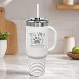 White 40 oz tumbler with handle and straw laser engraved with the Social Club "Dog Mom" design, on a kitchen counter
