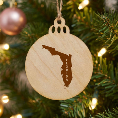 Florida round wood Christmas ornament engraved with the state shape and FLORIDA in vertical lettering