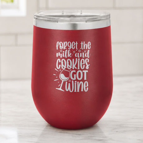 Maroon 12 oz stemless wine tumbler laser engraved with "Forget the Milk and Cookies, I've Got Wine", on a kitchen counter