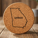 Georgia round cork coaster engraved with the state outline and GEORGIA in hand-drawn brush lettering