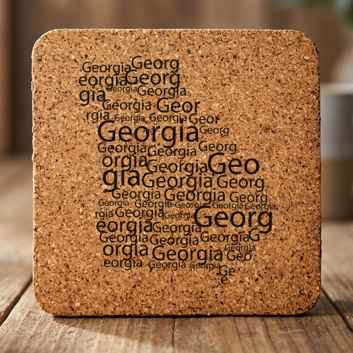 Georgia square cork coaster engraved with a word cloud of repeating Georgia text