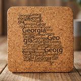 Georgia square cork coaster engraved with a word cloud of repeating Georgia text