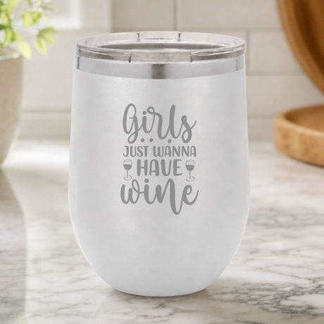 White 12 oz stemless wine tumbler laser engraved with "Girls Just Wanna Have Wine", on a kitchen counter