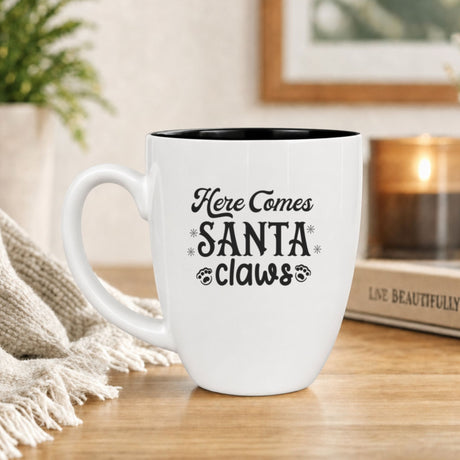 16 oz white ceramic coffee mug with "Here Comes Santa Claws"