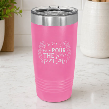 Pink 20 oz tumbler laser engraved with "Ho Ho Ho, Pour the Merlot", on a kitchen counter