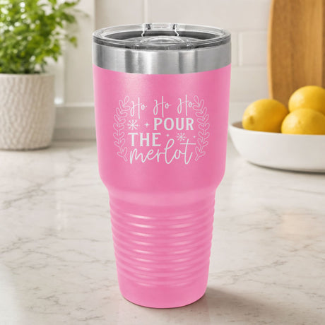 Pink 30 oz tumbler laser engraved with "Ho Ho Ho, Pour the Merlot", on a kitchen counter