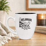 White 16 oz ceramic coffee mug printed with the Delaware state outline and The First State