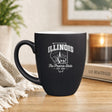 Black 16 oz ceramic coffee mug printed with the Illinois state outline and The Prairie State