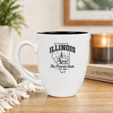 White 16 oz ceramic coffee mug printed with the Illinois state outline and The Prairie State
