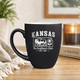 Black 16 oz ceramic coffee mug printed with the Kansas state outline and The Sunflower State