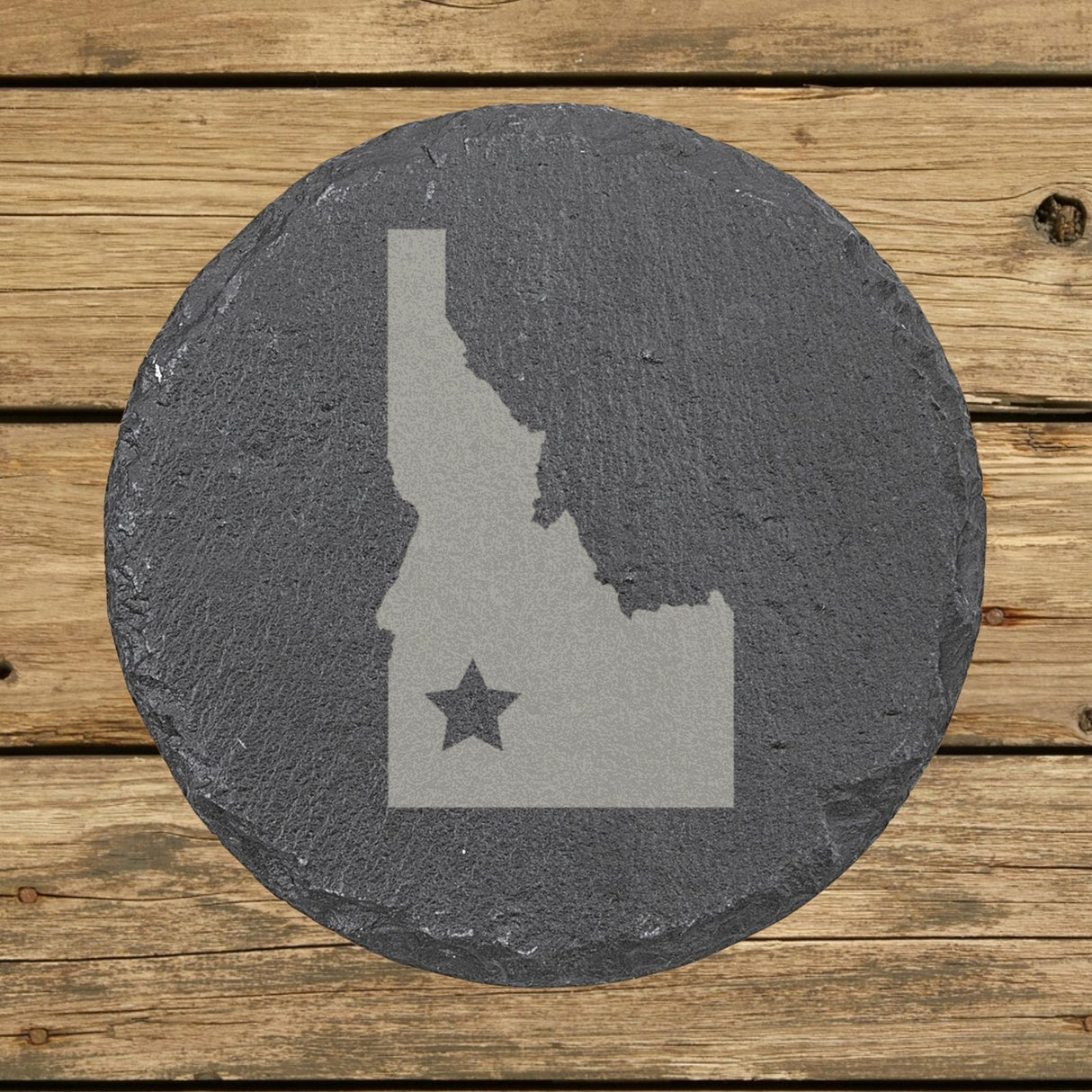 Idaho round slate coaster engraved with the state shape and a star