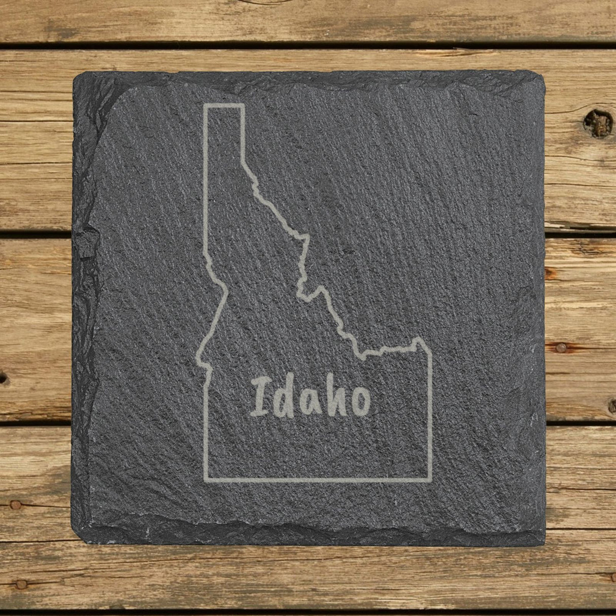 Idaho square slate coaster engraved with the state outline and IDAHO in hand-drawn brush lettering