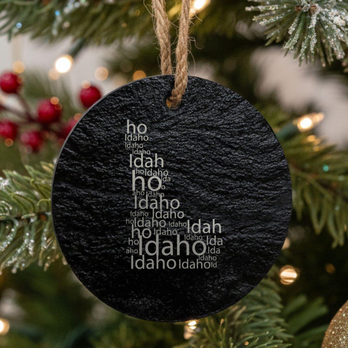 Idaho round slate Christmas ornament engraved with a word cloud of repeating Idaho text