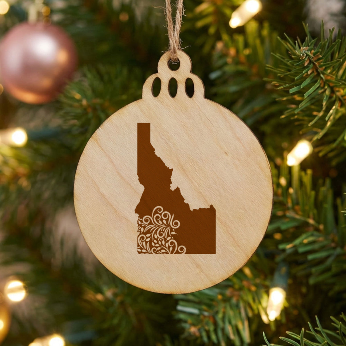 Idaho round wood Christmas ornament engraved with the state shape in ornate floral scrollwork
