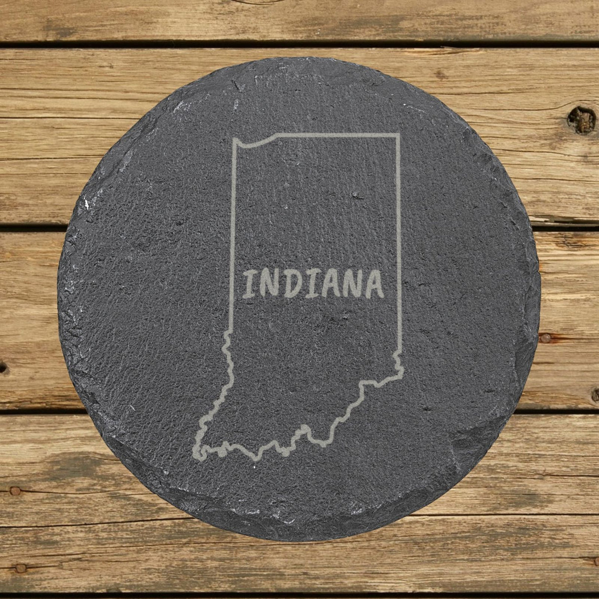 Indiana round slate coaster engraved with the state outline and INDIANA in hand-drawn brush lettering