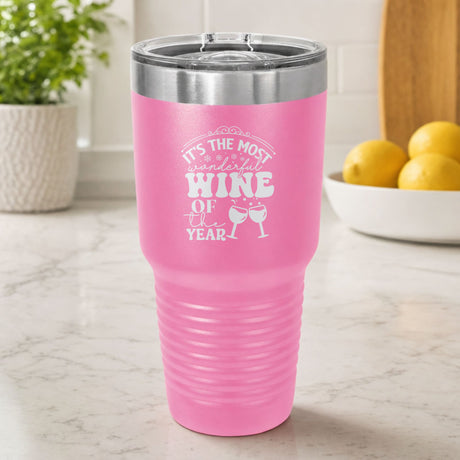 Pink 30 oz tumbler laser engraved with "It's the Most Wonderful Wine of the Year", on a kitchen counter