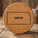 Kansas round cork coaster engraved with the state outline and KANSAS in hand-drawn brush lettering