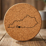 Kentucky round cork coaster engraved with the state outline and home in script with a heart
