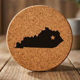 Kentucky round cork coaster engraved with the state shape and a star