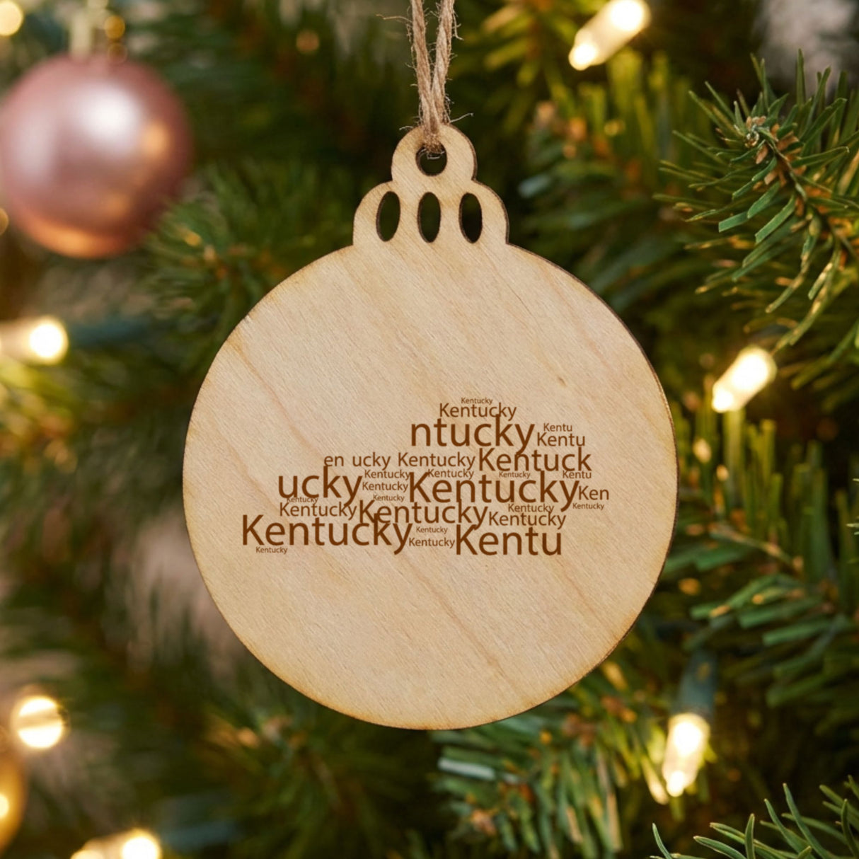 Kentucky round wood Christmas ornament engraved with a word cloud of repeating Kentucky text