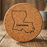 Louisiana round cork coaster engraved with the state outline and LOUISIANA in hand-drawn brush lettering