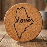 Maine round cork coaster engraved with a hand-drawn state outline and love in cursive