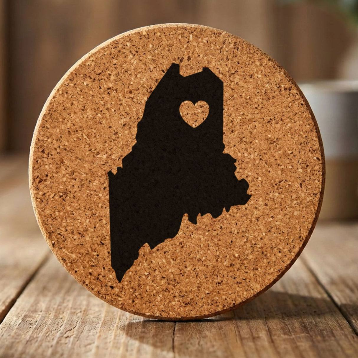 Maine round cork coaster engraved with the state shape and a heart