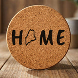 Maine round cork coaster engraved with HOME using the state outline as the letter O