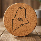 Maine round cork coaster engraved with the state outline and ME initials