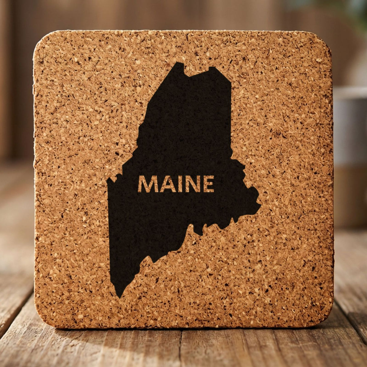 Maine square cork coaster engraved with the state shape and MAINE in bold lettering