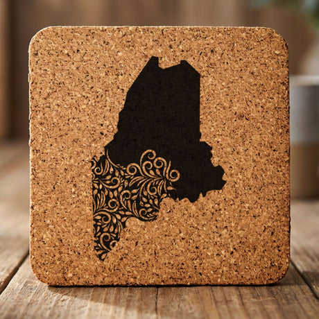 Maine square cork coaster engraved with the state shape in ornate floral scrollwork
