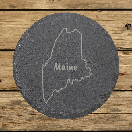 Maine round slate coaster engraved with the state outline and MAINE in hand-drawn brush lettering