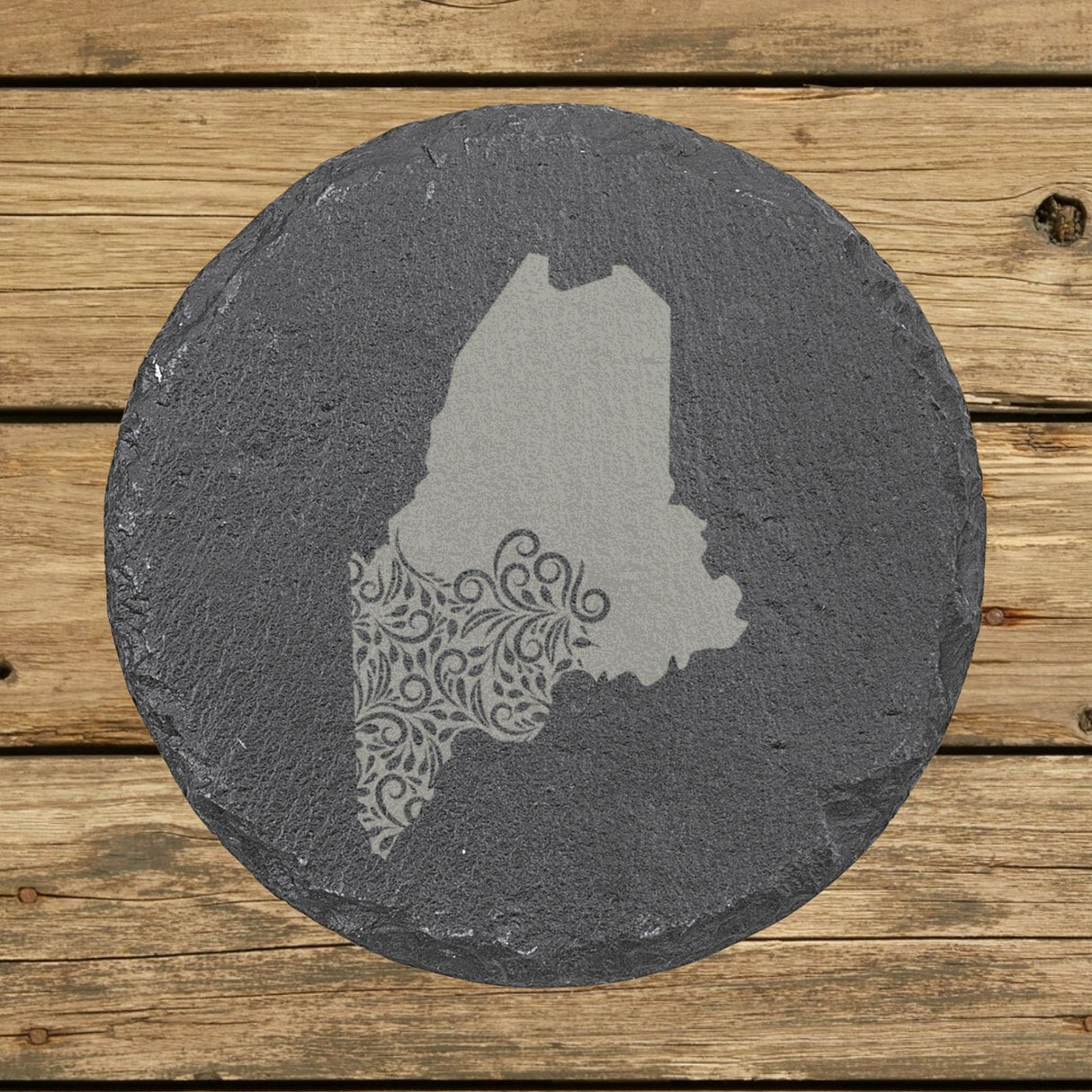 Maine round slate coaster engraved with the state shape in ornate floral scrollwork
