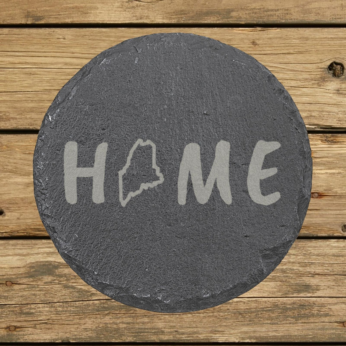 Maine round slate coaster engraved with HOME using the state outline as the letter O