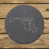 Maryland round slate coaster engraved with the state outline and MARYLAND in hand-drawn brush lettering