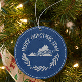 Blue leatherette round Christmas ornament engraved Merry Christmas From Virginia, with the state shape in a laurel wreath, hanging on a tree