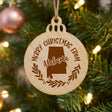 Round wood Christmas ornament engraved Merry Christmas From Alabama, with the state shape in a laurel wreath