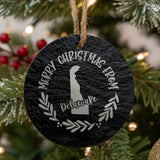 Round slate Christmas ornament engraved Merry Christmas From Delaware, with the state shape in a laurel wreath
