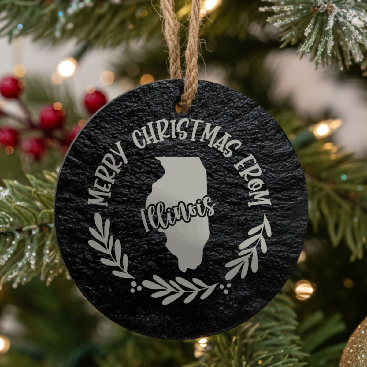 Round slate Christmas ornament engraved Merry Christmas From Illinois, with the state shape in a laurel wreath