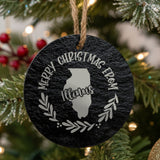 Round slate Christmas ornament engraved Merry Christmas From Illinois, with the state shape in a laurel wreath