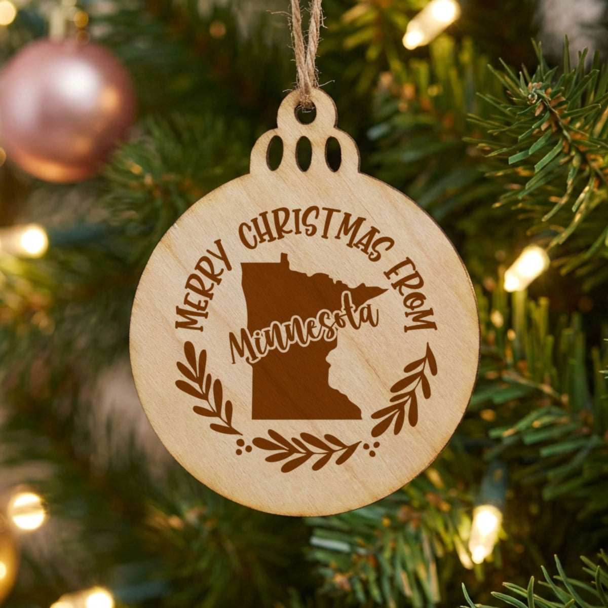 Round wood Christmas ornament engraved Merry Christmas From Minnesota, with the state shape in a laurel wreath