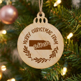 Round wood Christmas ornament engraved Merry Christmas From Nebraska, with the state shape in a laurel wreath