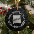 Round slate Christmas ornament engraved Merry Christmas From New Mexico, with the state shape in a laurel wreath