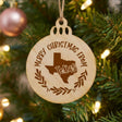 Round wood Christmas ornament engraved Merry Christmas From Texas, with the state shape in a laurel wreath