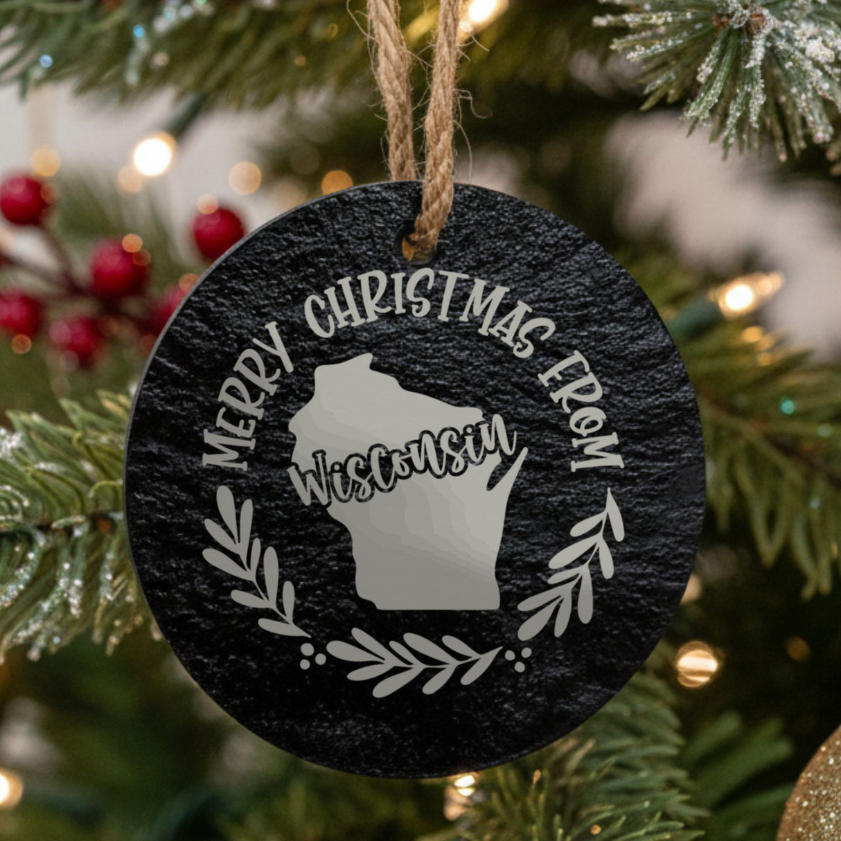 Round slate Christmas ornament engraved Merry Christmas From Wisconsin, with the state shape in a laurel wreath