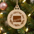 Round wood Christmas ornament engraved Merry Christmas From Wyoming, with the state shape in a laurel wreath