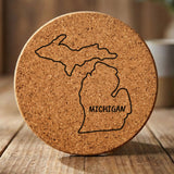 Michigan round cork coaster engraved with the state outline and MICHIGAN in hand-drawn brush lettering