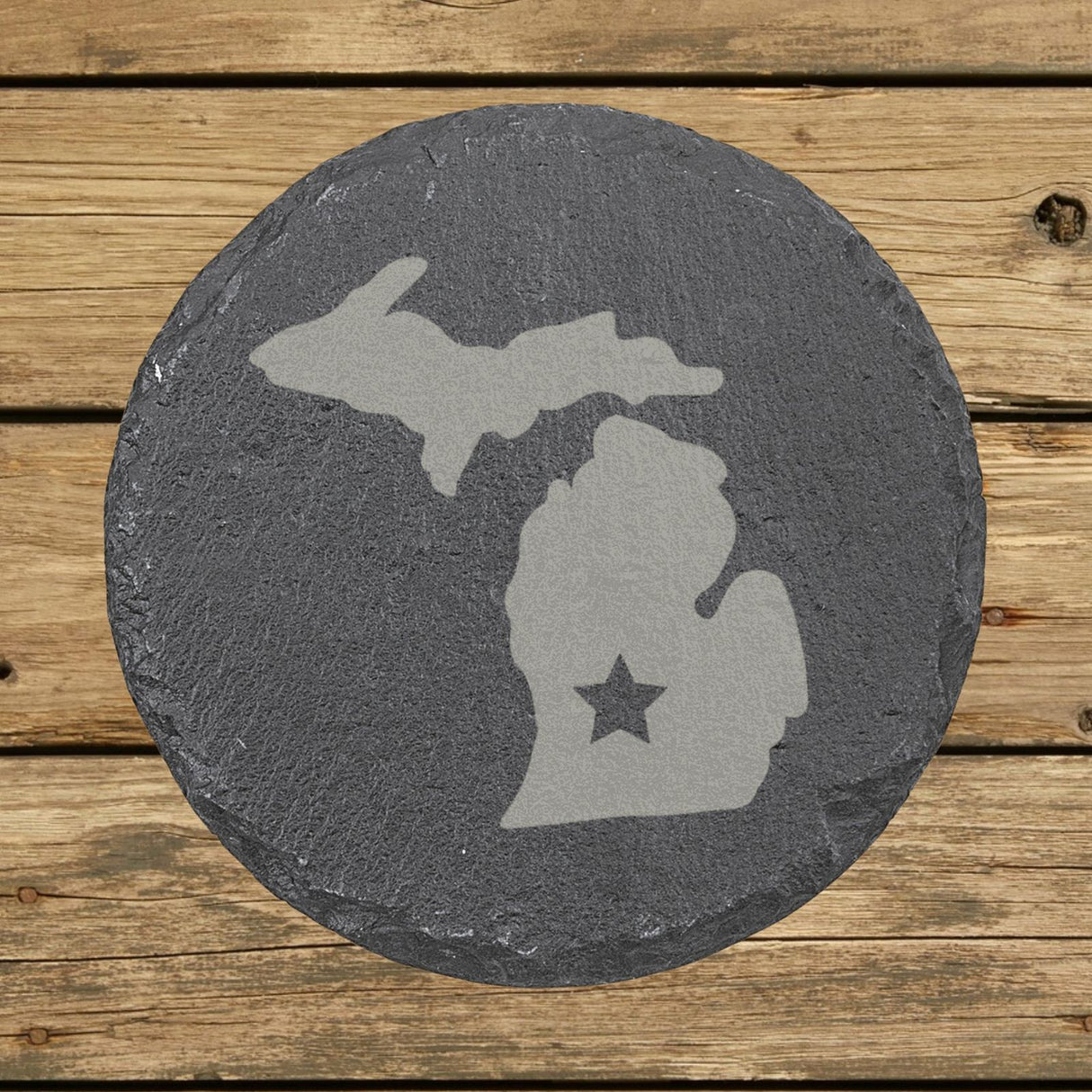 Michigan round slate coaster engraved with the state shape and a star